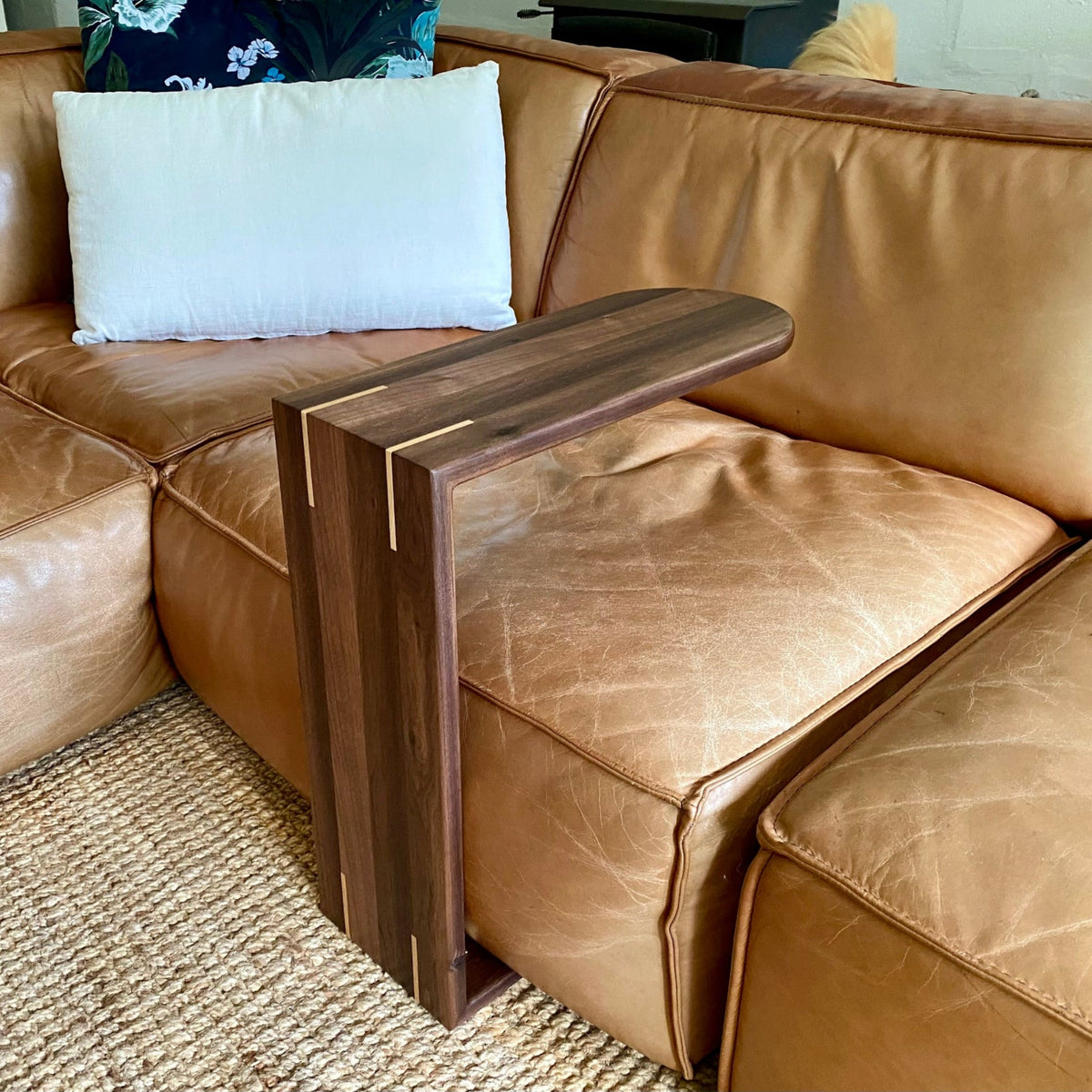 A  Black Walnut C side table, shown slid over a leather couch