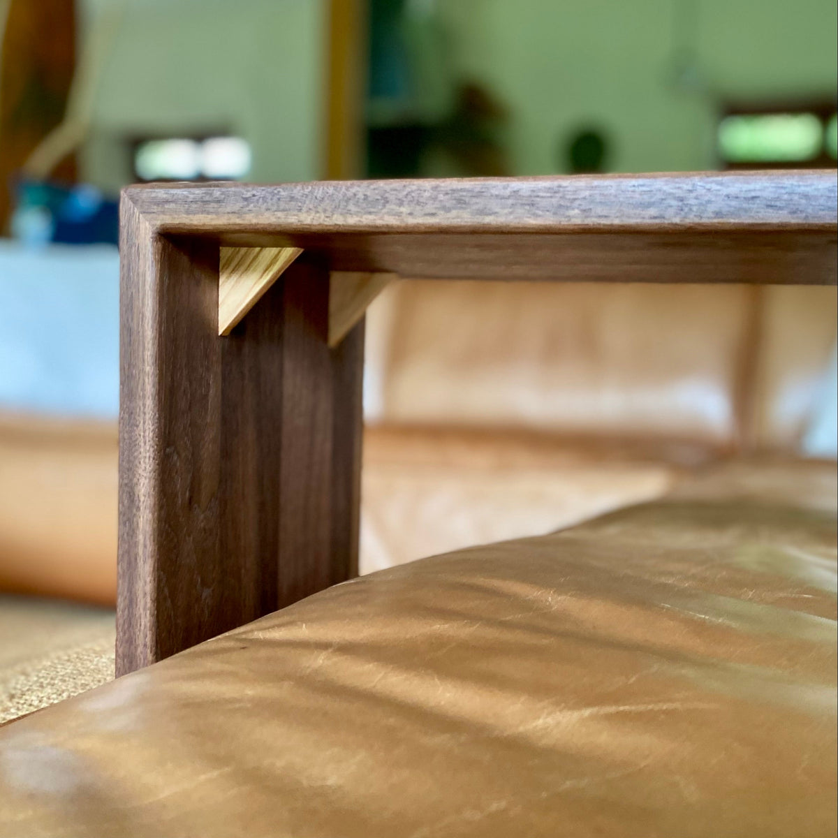 A close up of the underside of a Black Walnut C table showing the contrasting White Ash timber splines in the mitre join