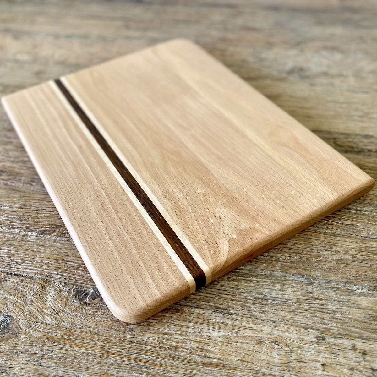 European beech chopping board with Kwila and maple stripe flat lay on rustic timber surface – East Wood Design