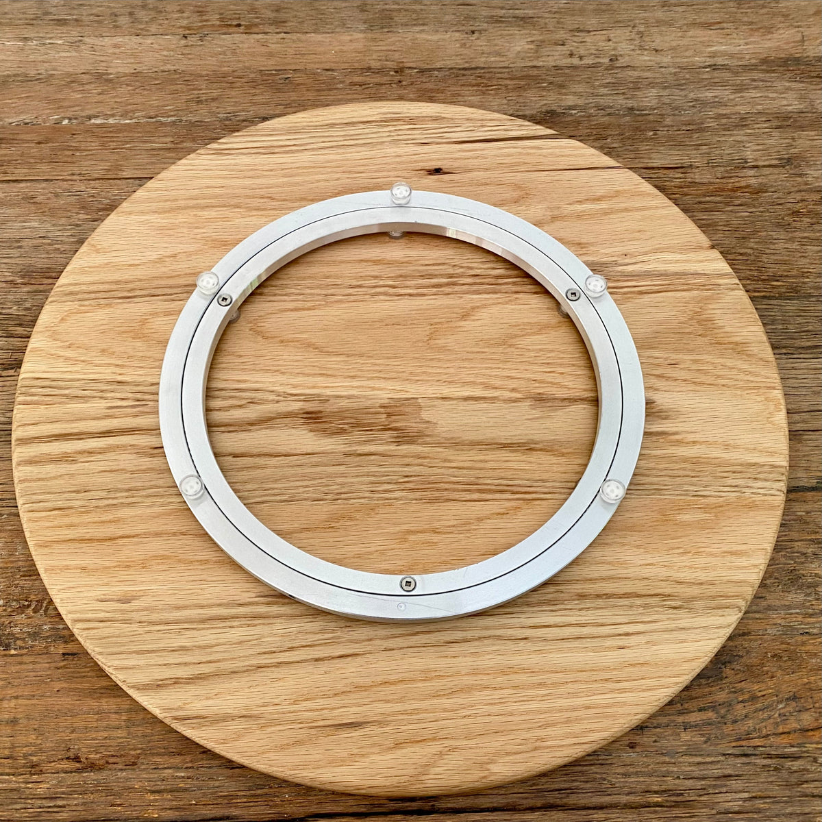 A round white oak lazy Susan, turntable showing the underside with the metal turntable mechanism