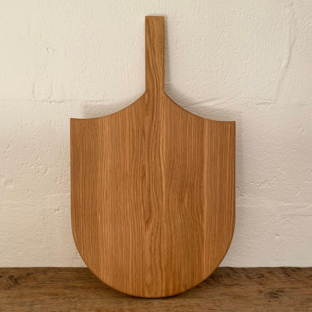 The Ray Board in American White Oak – front view leaning against white wall showing sting ray inspired shape and handle