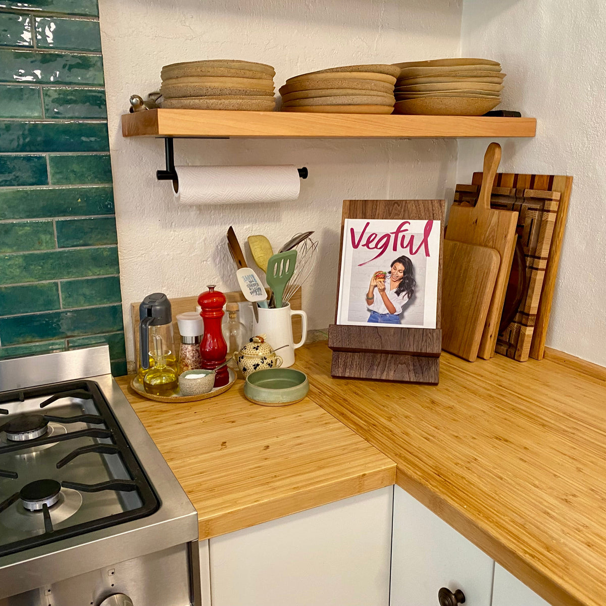 Book stand in Black Walnut holding a cookbook, front three-quarter view in styled kitchen setting