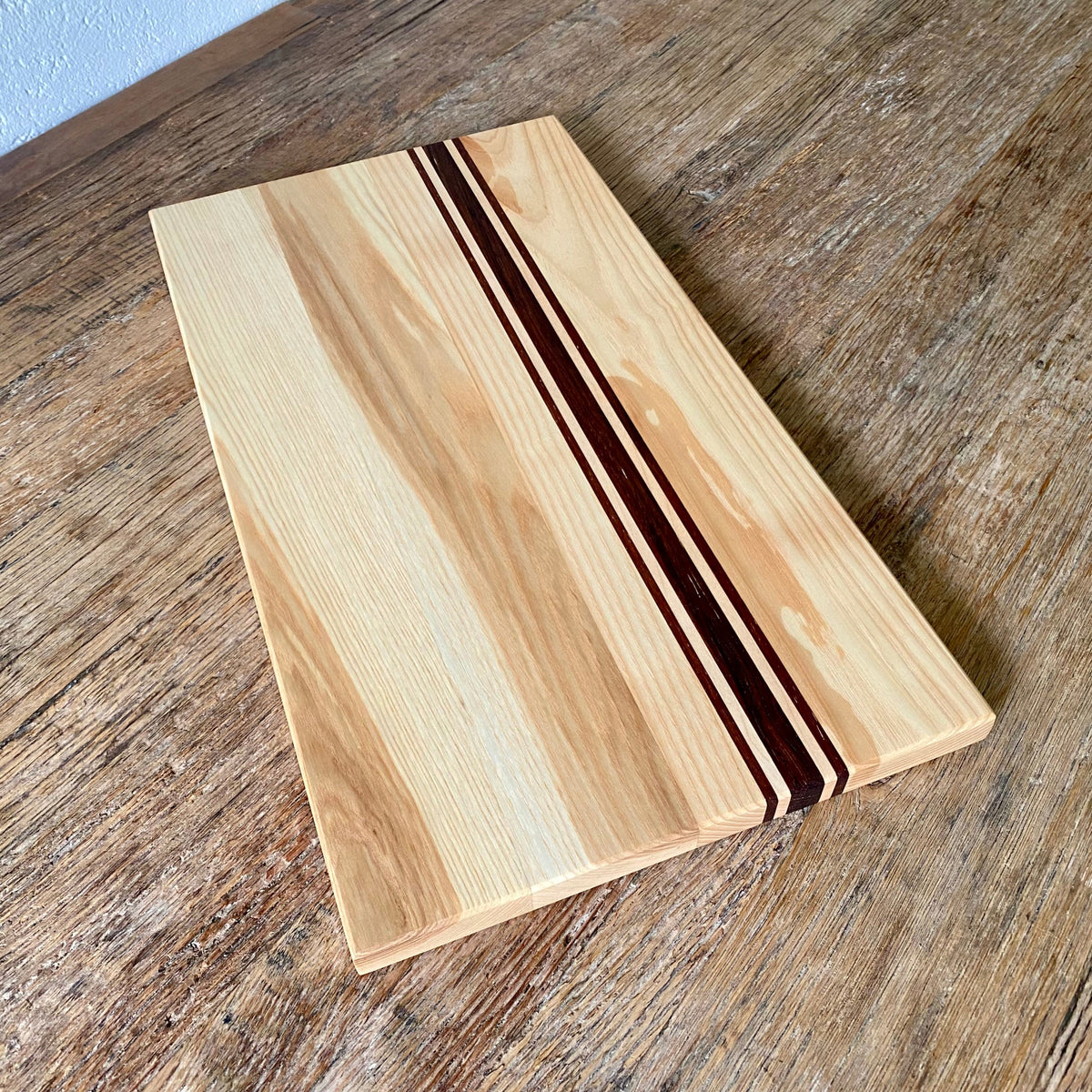Ash Long platter Board with Kwila and Maple stripes running the length just off centre. detail view