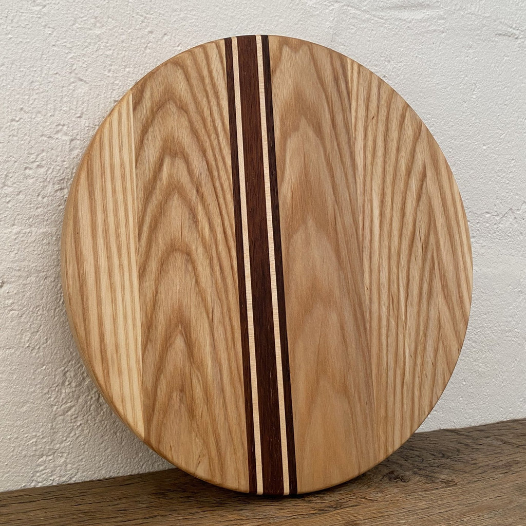 The Rounds American Ash with Kwila and Maple stripe – upright against white wall showing full face