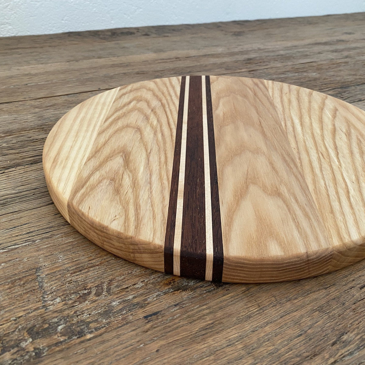 The Rounds American Ash with Kwila and Maple stripe – angled lifestyle view showing edge and grain
