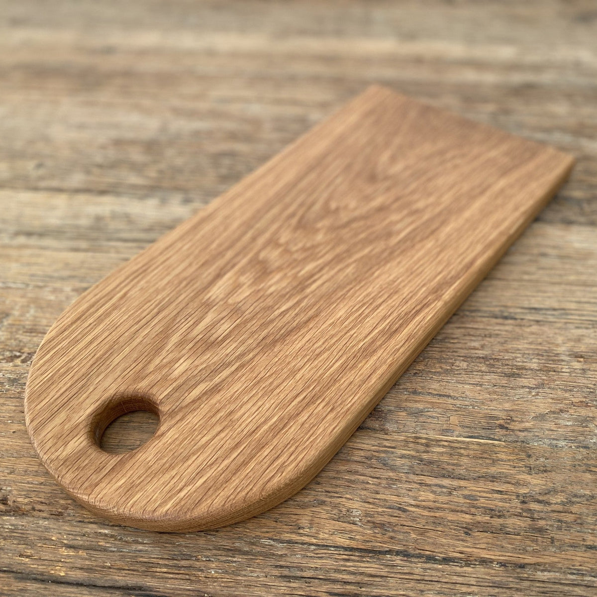 White oak arc platter with finger hole, teardrop shape flat lay on rustic timber surface – East Wood Design