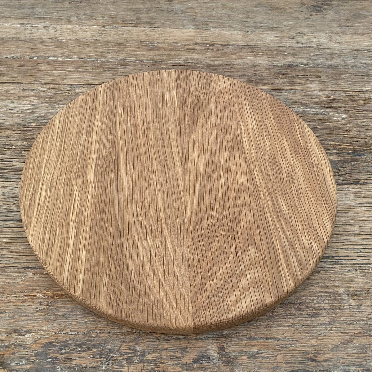 The Round White Oak serving board – flat lay top-down view on rustic timber surface