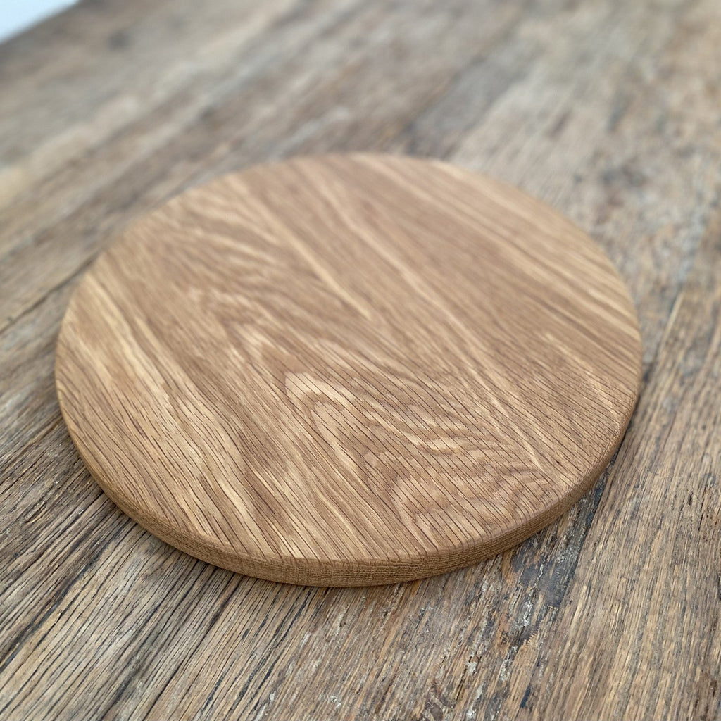 The Round White Oak serving board – angled lifestyle view on rustic timber surface